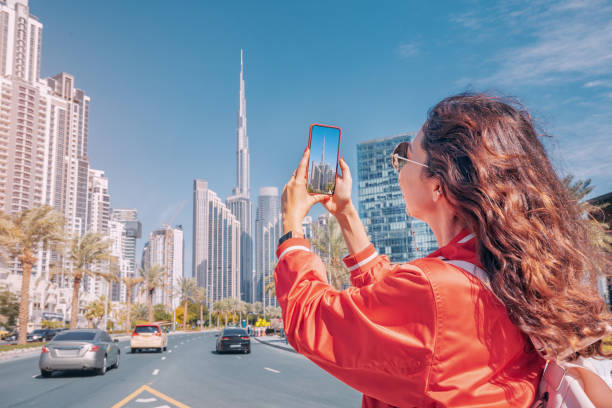 A woman takes a photo of Dubai's skyline, highlighting the appeal of freelancing in the city's vibrant economy.