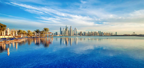 Dubai skyline reflecting in a beachfront pool, relevant to freelance visa and permit procedures in 2024.